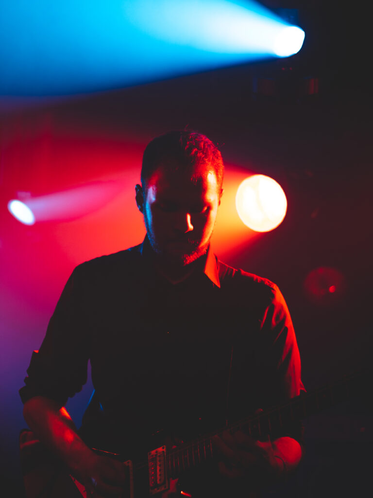 Fotoshoot in Gouda tijdens optreden, gitarist met rood en blauw licht